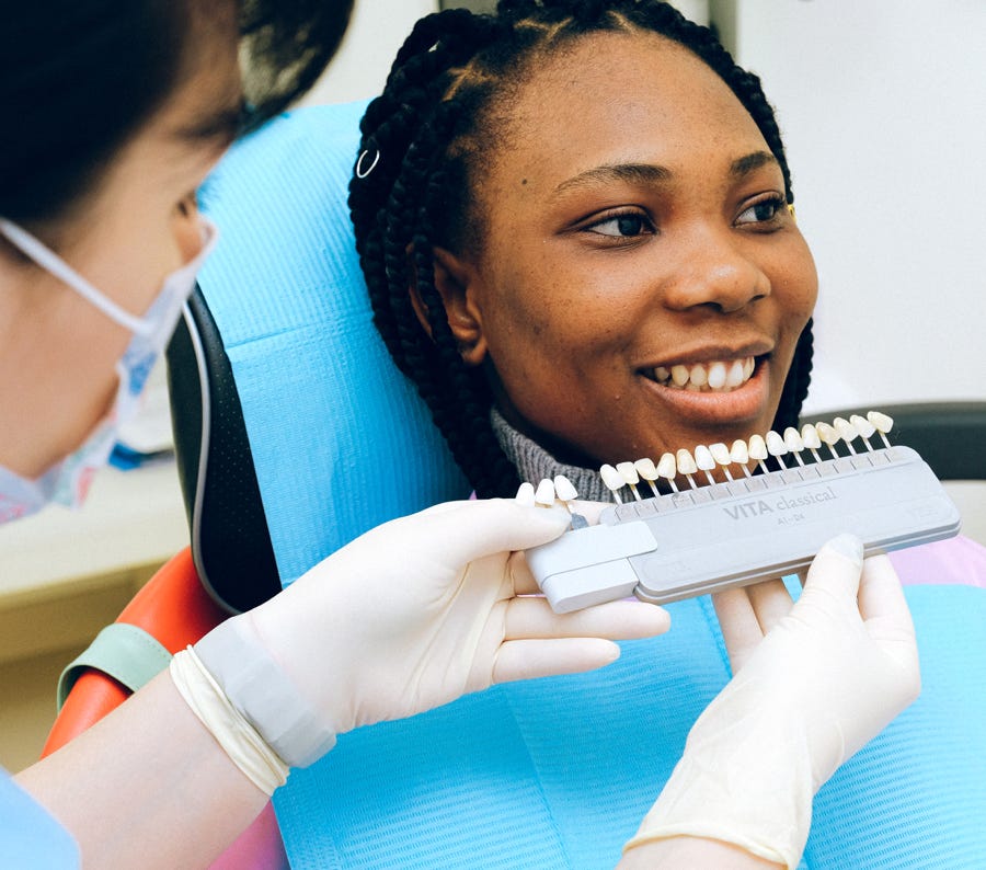 Sonriente Dama étnica Visitar Al Dentista En La Clínica Moderna